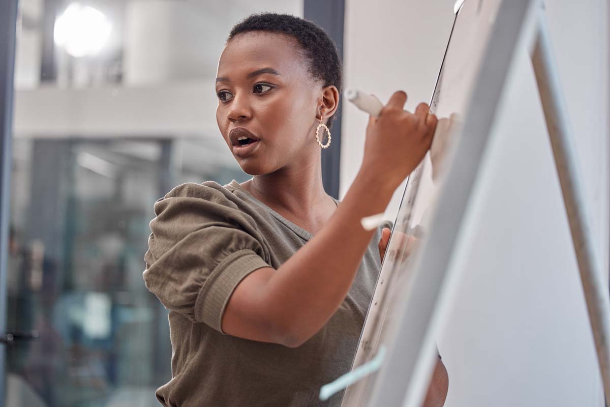 Business, board and black woman with presentation, planning and explain process at a workshop. Female person, presenter and speaker writing, brainstorming and motivation with profit growth and mentor.